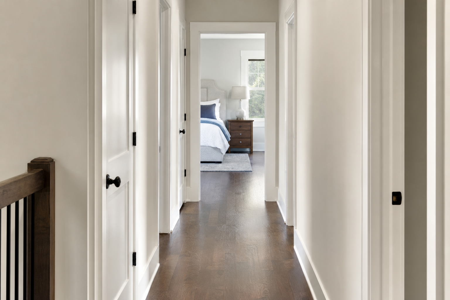 Finished bedroom hallway with refined hardwood flooring
