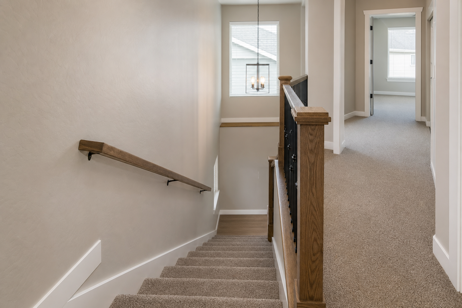 Finished carpeted staircase and upstairs hallway in a bright Layton home.