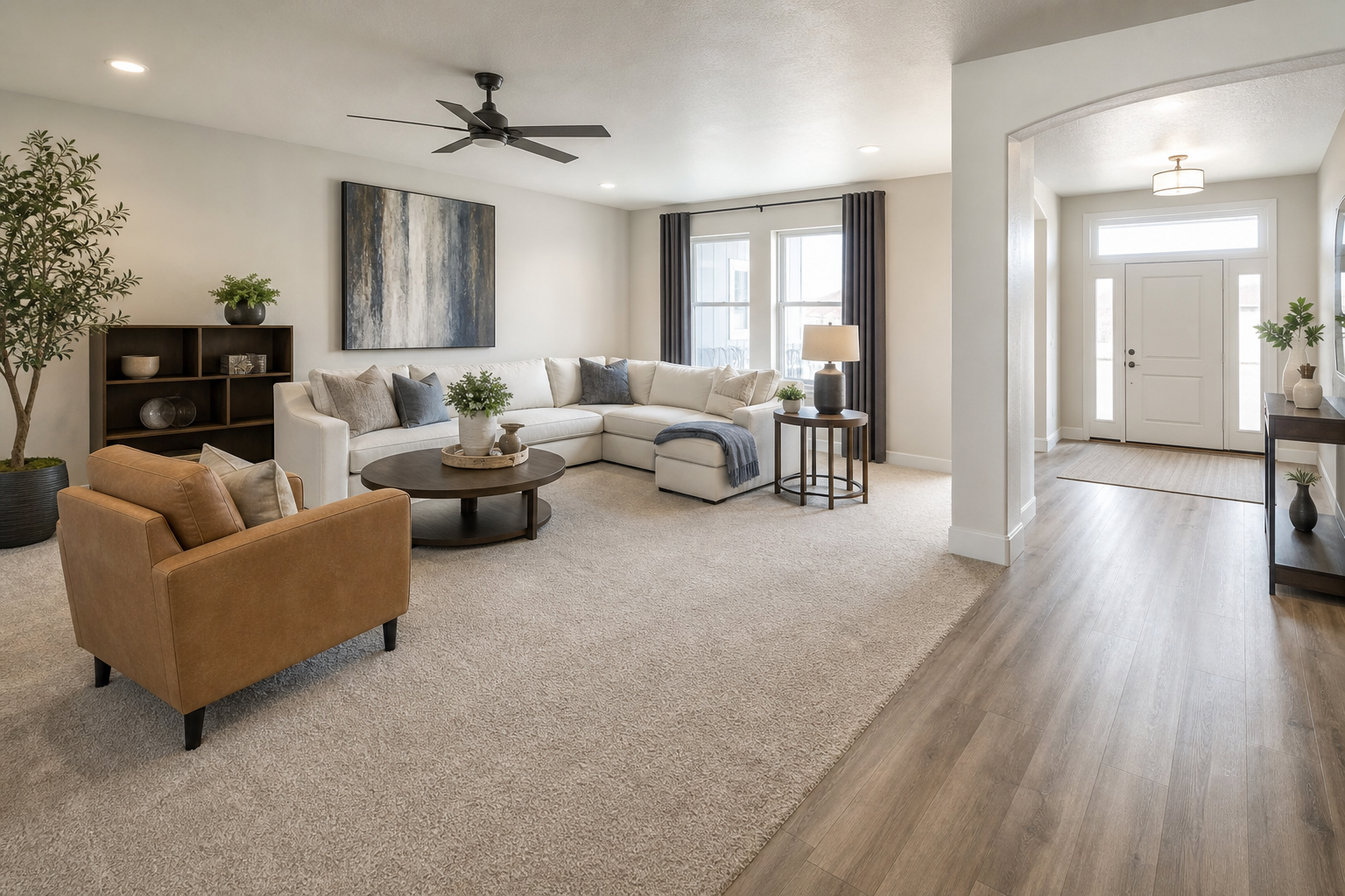 Finished family room with carpet transitioning to hard flooring in an adjacent entry.